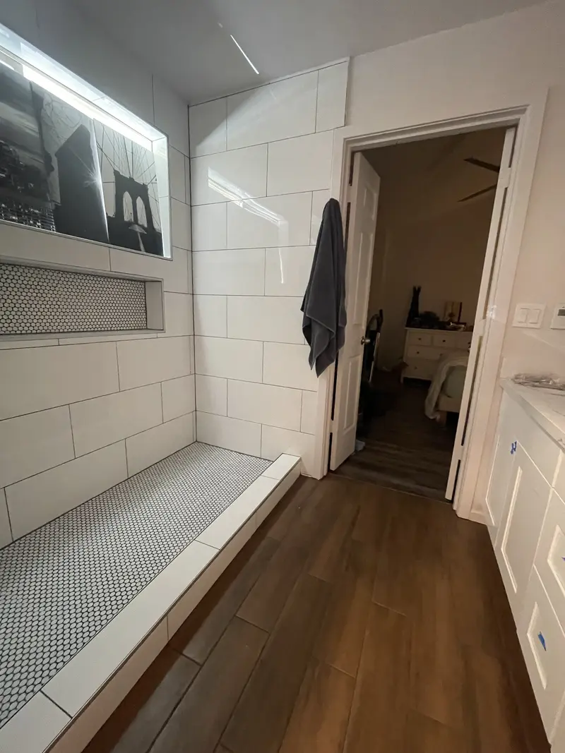 Shower ledge and niche looking back toward the bathroom door