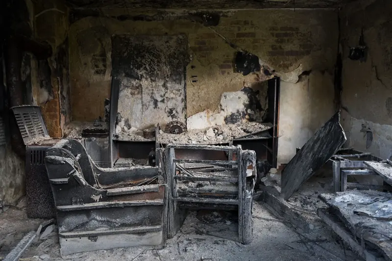 Living room with furniture and walls charred by fire