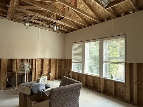 Living room with the ceiling drywall and lower walls removed after a water leak