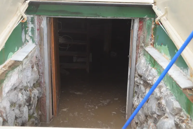 Muddy water standing at the bottom of a basement stairwell