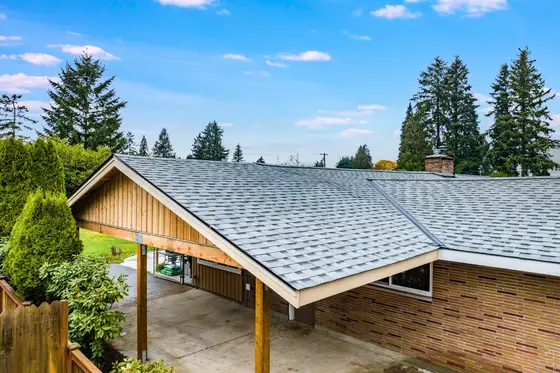 New asphalt shingle gable roof over a rebuilt carport tying into a brick ranch house in Auburn, WA