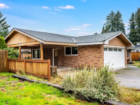Brick ranch house with a rebuilt carport under a board and batten gable in Auburn, WA