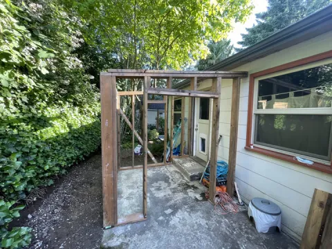 Wood wall framing for a shed against the side of a house before siding in Seattle, WA