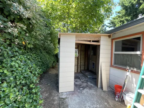 Lap siding installed on the front walls of a new shed next to a house in Seattle, WA