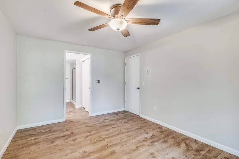 Second bedroom with a ceiling fan looking out to the hallway