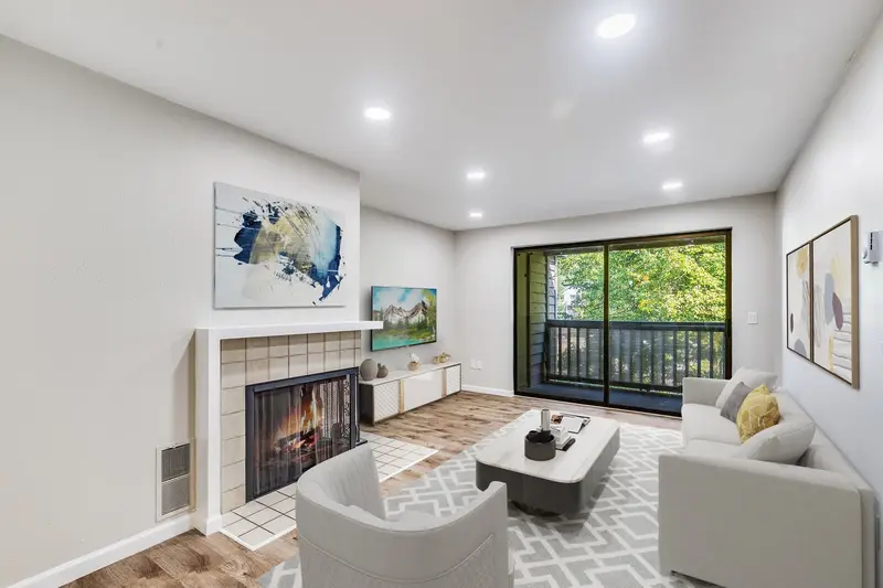 Condo living room with a tiled fireplace, plank floor, recessed lights and a sliding door to the balcony