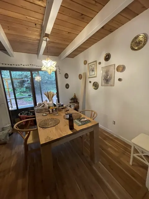 Dining room with a new wood floor, a white-beamed wood ceiling and a star pendant light over a wood table