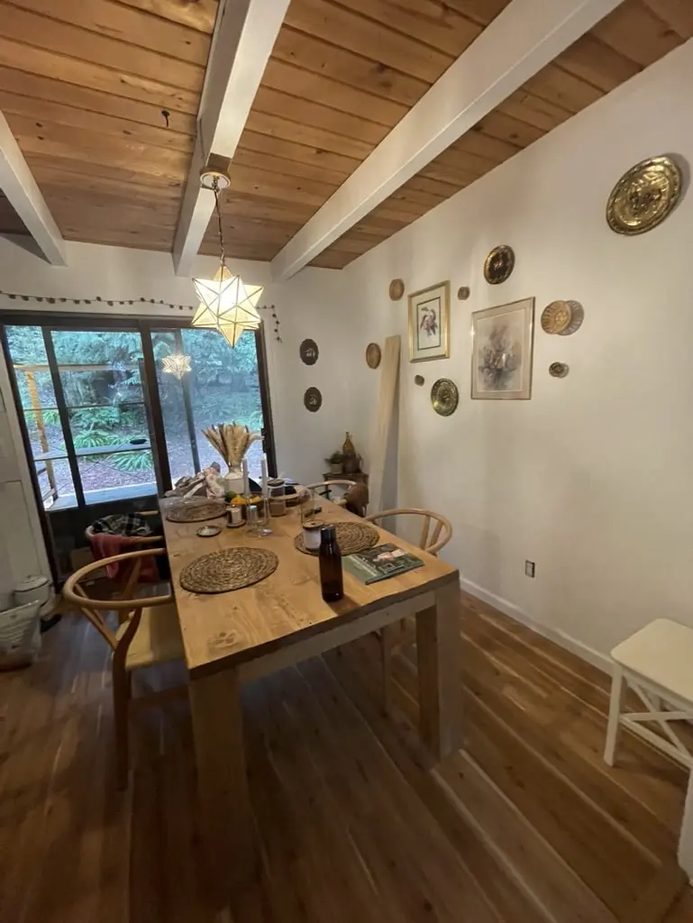 Dining room with a new wood floor, a white-beamed wood ceiling and a star pendant light over a wood table