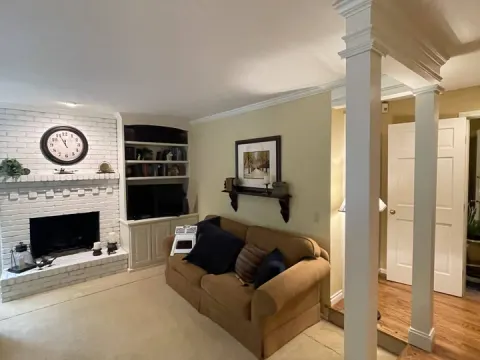 Living room in Sammamish, WA with a white brick fireplace, built in shelves and a new column and beam