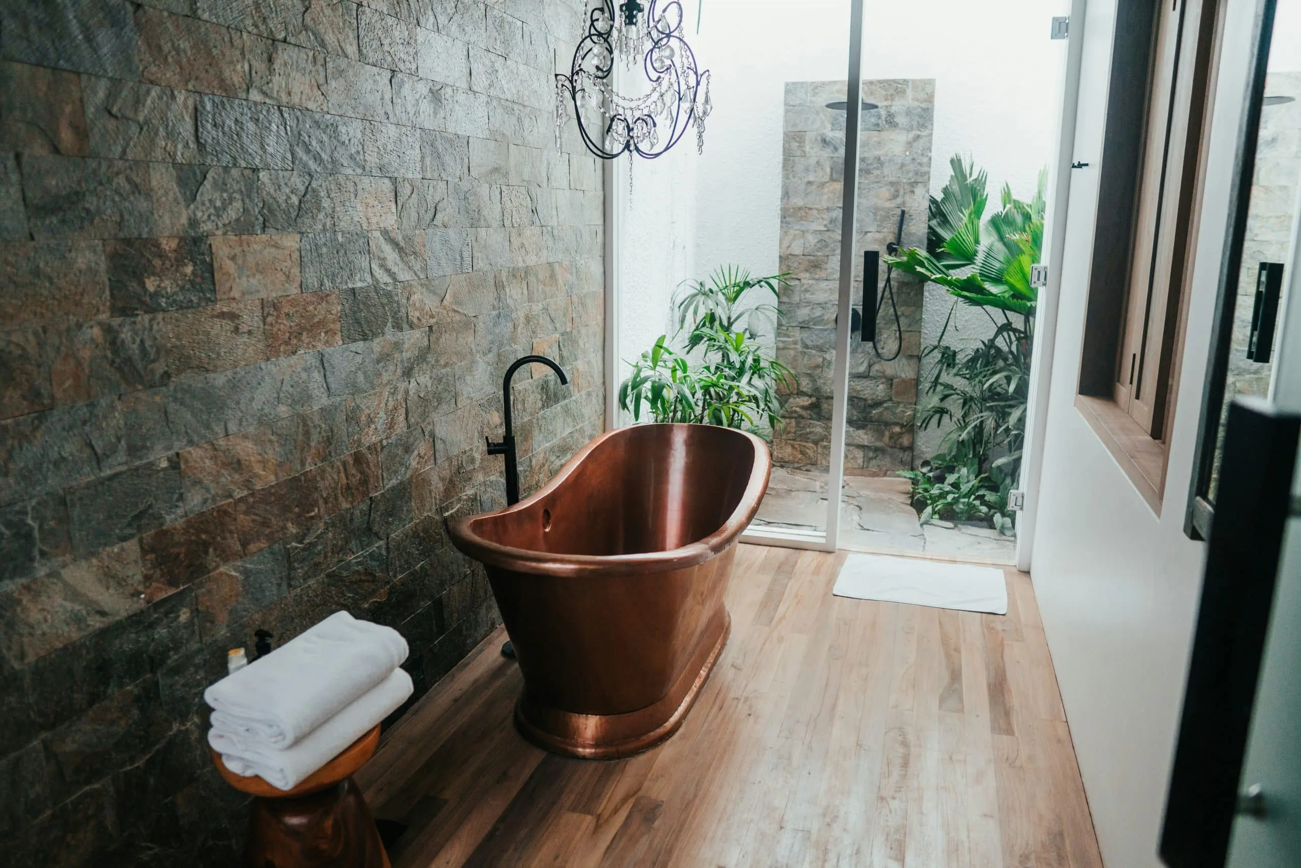 Bathroom with a slate stone wall, a copper tub and a separate shower