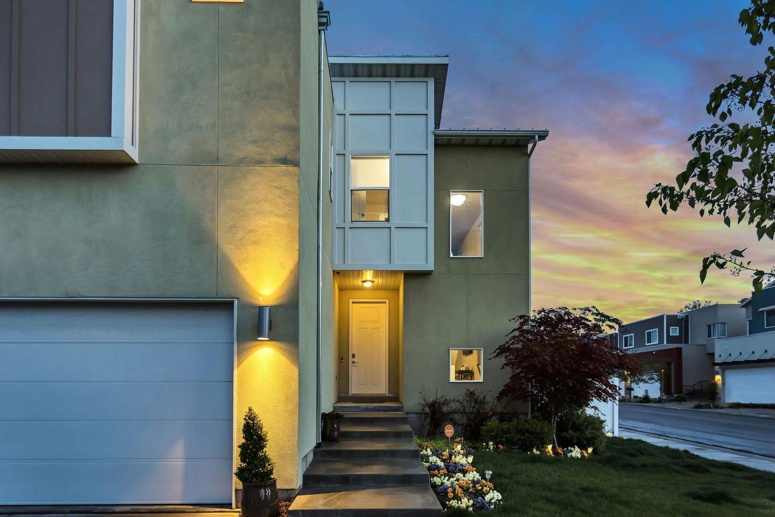 Split-level house exterior at dusk with steps up to the front door