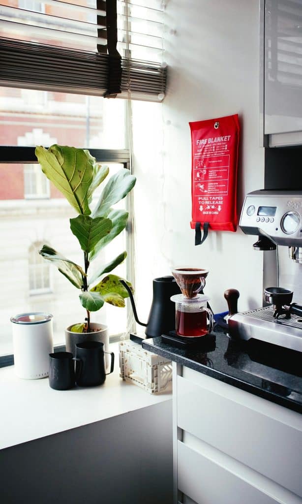 red and silver coffee maker beside white ceramic mug