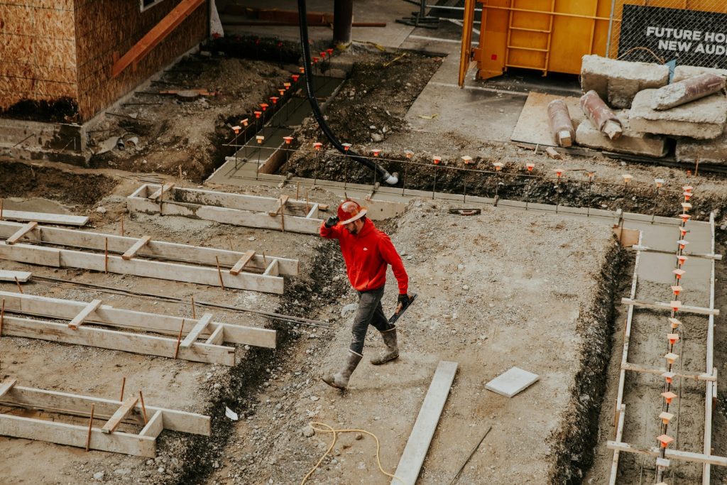 man in red jacket and black pants walking on gray concrete stairs